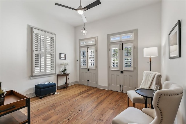 living area featuring wood-type flooring and ceiling fan