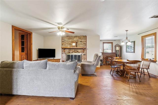 living room featuring hardwood / wood-style flooring, a fireplace, ceiling fan, and a wealth of natural light