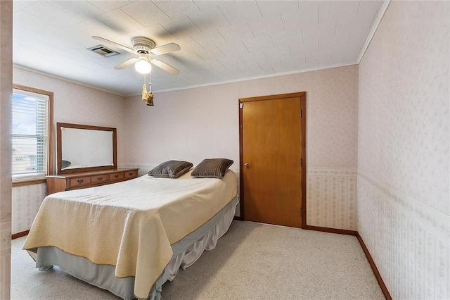 bedroom with crown molding, light carpet, and ceiling fan