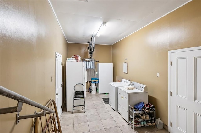 laundry area with independent washer and dryer and light tile patterned flooring