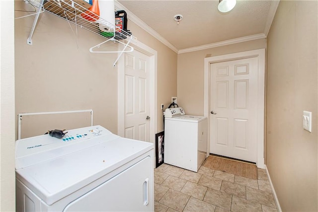 clothes washing area with a textured ceiling, washer and clothes dryer, and ornamental molding