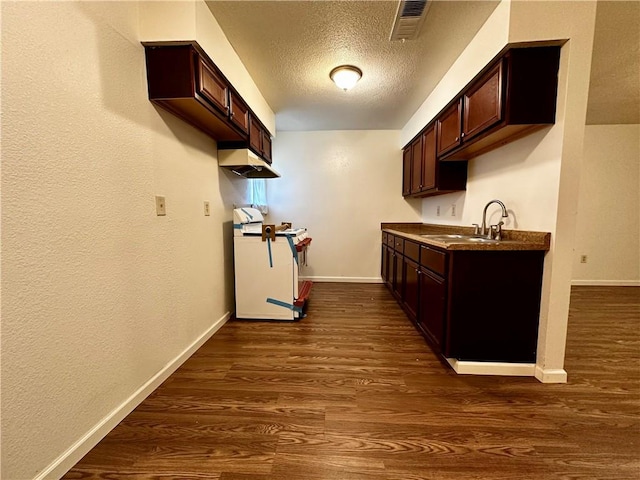 kitchen featuring dark brown cabinetry, sink, a textured ceiling, dark wood-type flooring, and white range