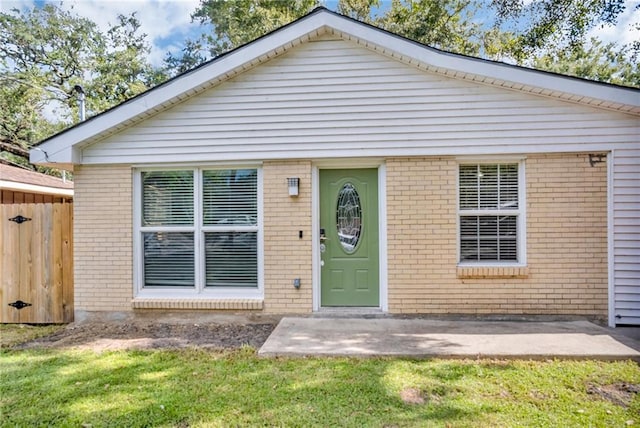 bungalow with a front lawn and a patio