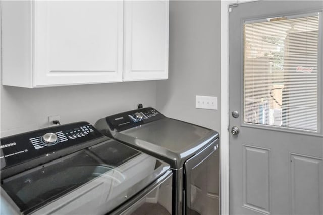 clothes washing area featuring cabinets, plenty of natural light, and independent washer and dryer