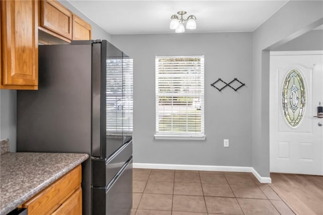 kitchen with fridge, a chandelier, and tile patterned floors