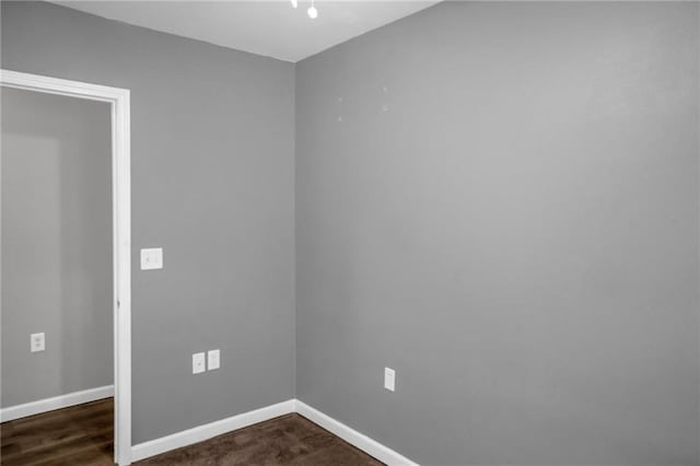 empty room with dark hardwood / wood-style flooring