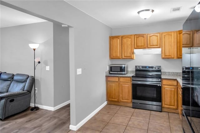 kitchen with appliances with stainless steel finishes and light tile patterned floors