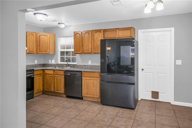 kitchen featuring sink, light tile patterned floors, and black appliances