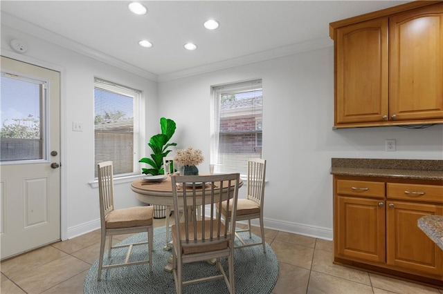 tiled dining area featuring crown molding and a healthy amount of sunlight