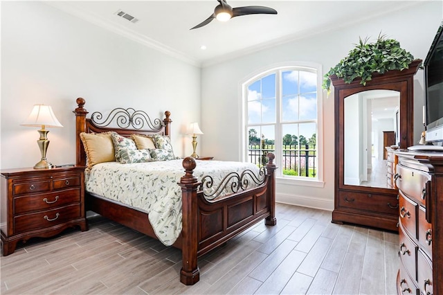 bedroom featuring light hardwood / wood-style flooring, ceiling fan, multiple windows, and crown molding