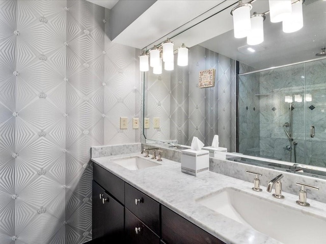 bathroom featuring a shower with door and vanity