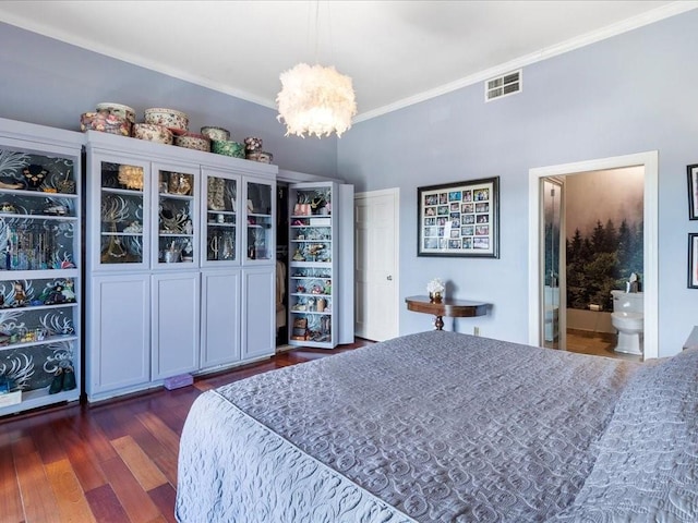 bedroom featuring connected bathroom, dark wood-type flooring, crown molding, and a chandelier