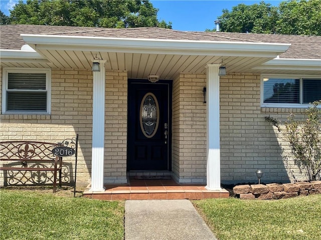 view of exterior entry with a yard