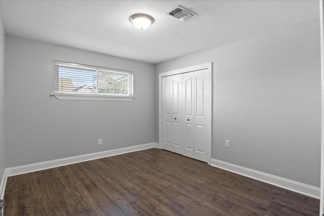 2016 Pelitere Cv, Chalmette, LA 70043 - unfurnished bedroom featuring a closet, dark wood-type flooring, visible vents, and baseboards