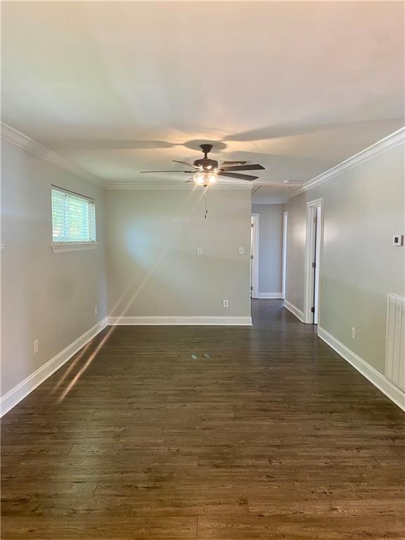 spare room with ceiling fan, dark hardwood / wood-style floors, and crown molding