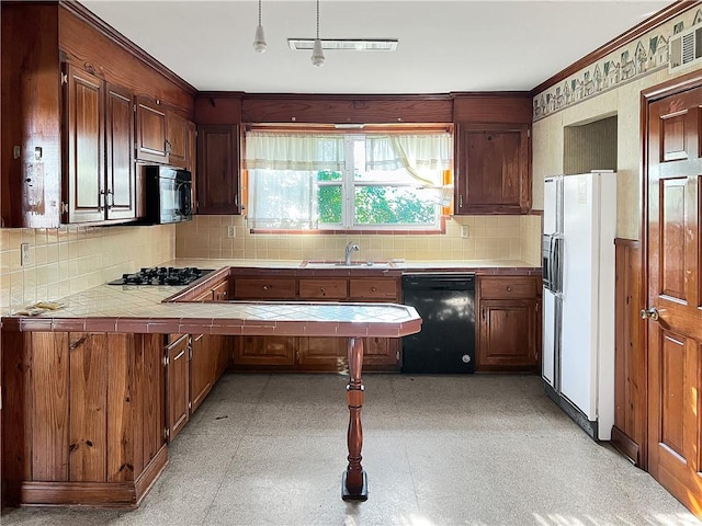 kitchen with tile counters, sink, kitchen peninsula, backsplash, and black appliances