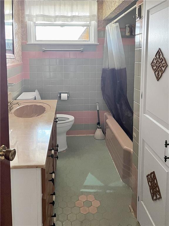 full bathroom with a wealth of natural light, tile patterned floors, vanity, and toilet