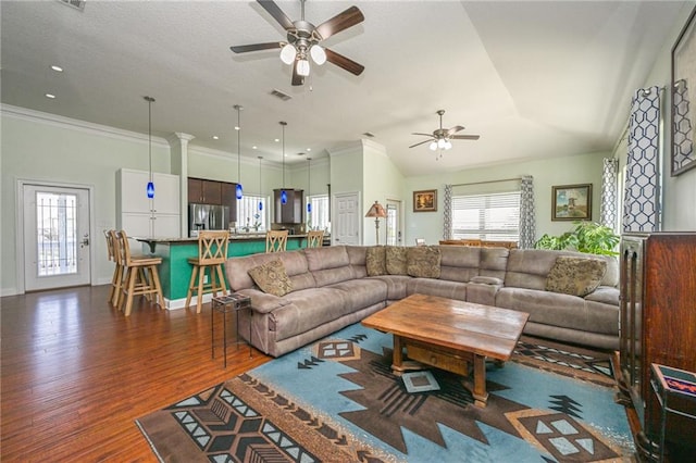 living room featuring ornamental molding, lofted ceiling, ceiling fan, and dark wood-type flooring