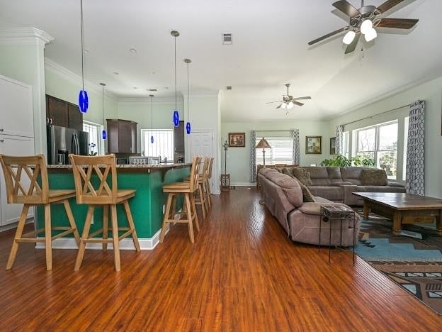 living room with ornamental molding, ceiling fan, and dark hardwood / wood-style flooring