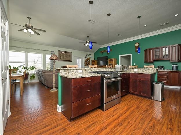 kitchen featuring light stone countertops, high end stove, ceiling fan, and dark hardwood / wood-style flooring