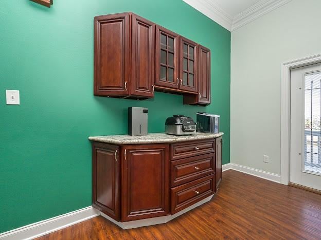 kitchen with ornamental molding and dark wood-type flooring