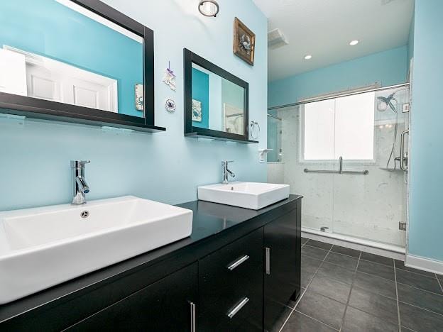 bathroom with walk in shower, vanity, and tile patterned floors