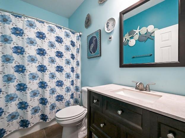 bathroom featuring a shower with curtain, vanity, tile patterned flooring, and toilet