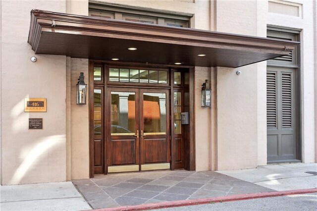416 Common St Unit 6, New Orleans, LA 70130 - view of exterior entry with french doors and stucco siding
