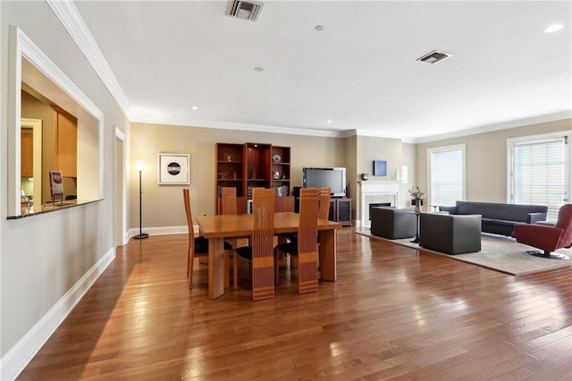 dining area featuring ornamental molding and hardwood / wood-style flooring