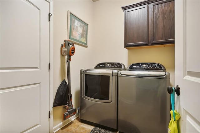 clothes washing area featuring separate washer and dryer and cabinets