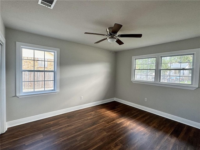 empty room featuring dark hardwood / wood-style floors, ceiling fan, and plenty of natural light