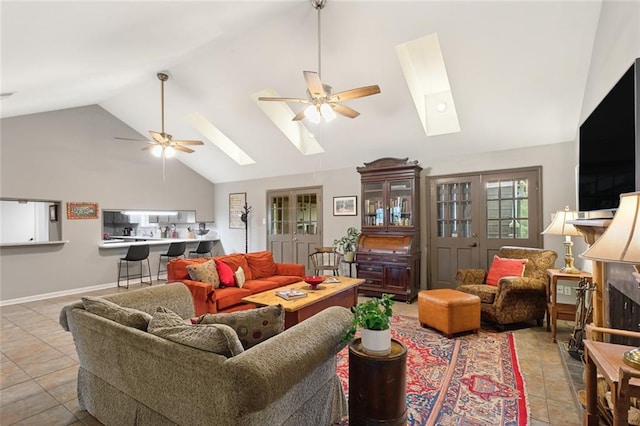 living room with ceiling fan, a skylight, and high vaulted ceiling