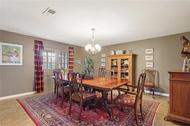 dining area with light tile patterned floors and a chandelier