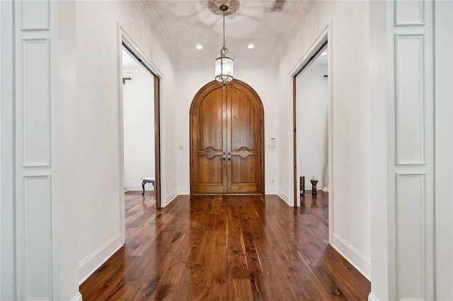 entryway with dark hardwood / wood-style floors and ornamental molding