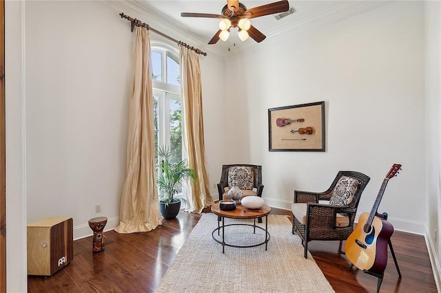 living area featuring dark hardwood / wood-style flooring, ceiling fan, and crown molding