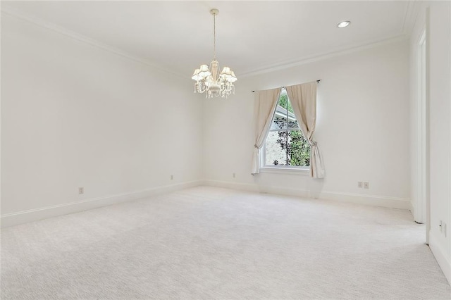 carpeted spare room featuring ornamental molding and a chandelier