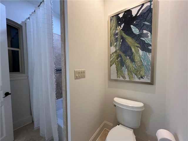 bathroom with a shower with curtain and toilet