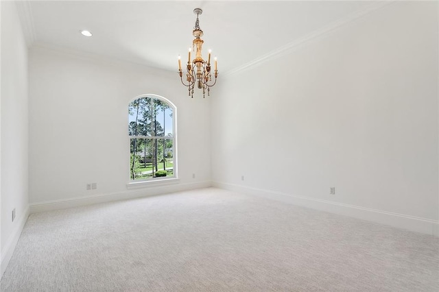 carpeted empty room with ornamental molding and a chandelier