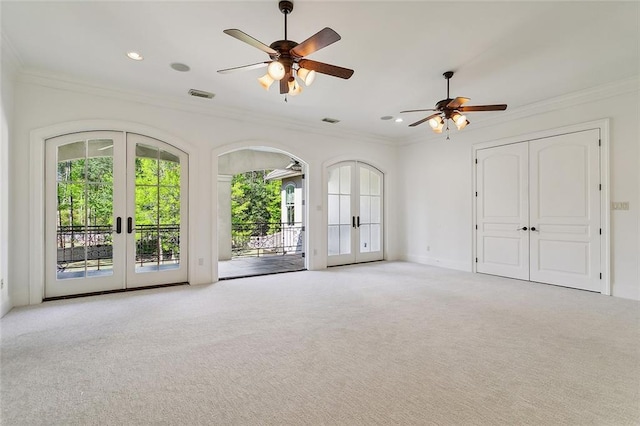 empty room featuring ceiling fan, ornamental molding, light carpet, and french doors