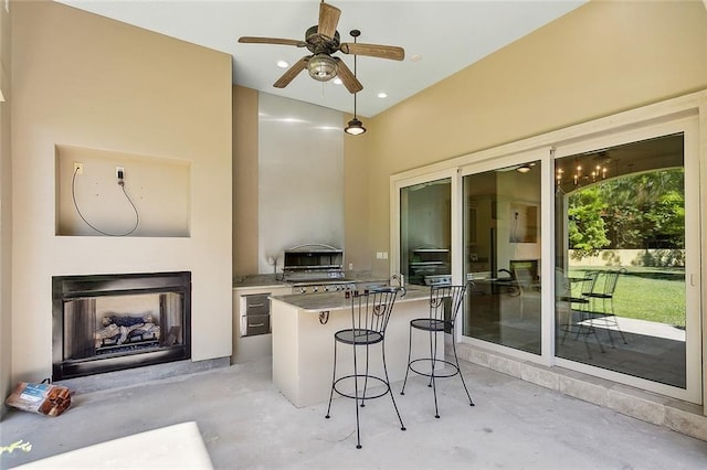 interior space with pendant lighting, a breakfast bar area, and ceiling fan