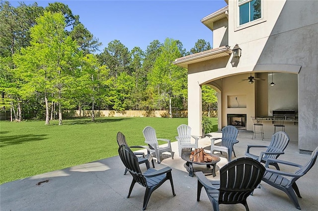 view of patio with ceiling fan and a fire pit