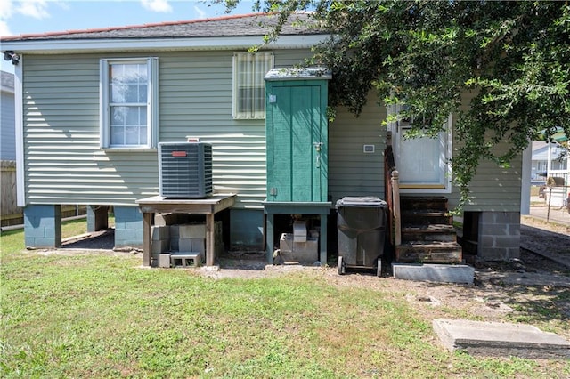 back of house with a lawn and central AC