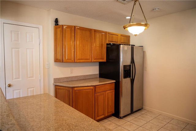 kitchen with stainless steel refrigerator with ice dispenser and light tile patterned floors