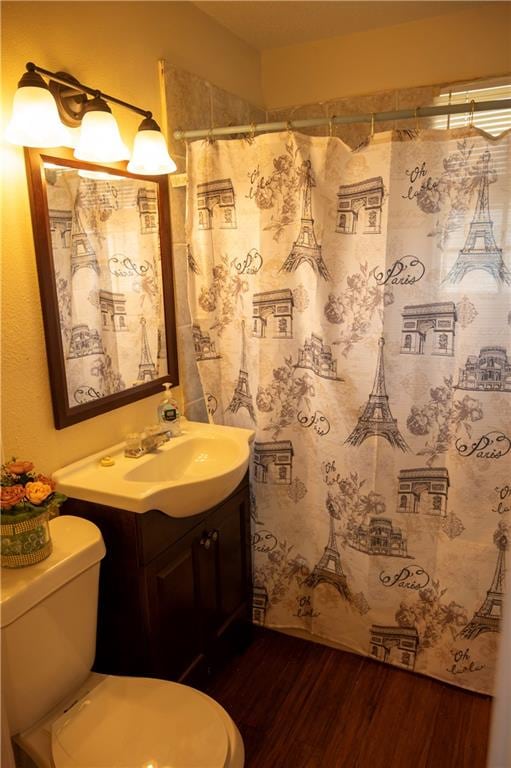 bathroom featuring hardwood / wood-style floors, curtained shower, vanity, and toilet