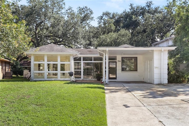 view of front of house with a sunroom and a front lawn