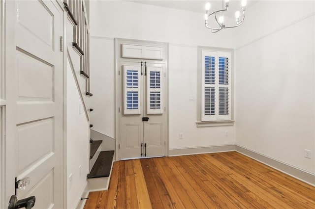 foyer with a notable chandelier and hardwood / wood-style floors