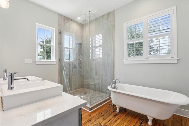 bathroom featuring independent shower and bath, wood-type flooring, and plenty of natural light