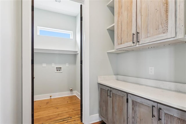 washroom featuring cabinets, light hardwood / wood-style floors, and hookup for a washing machine