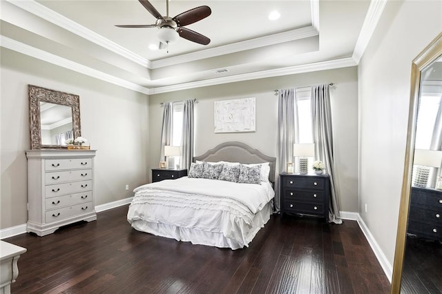 bedroom featuring ceiling fan, a raised ceiling, dark hardwood / wood-style floors, and ornamental molding