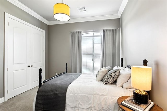 carpeted bedroom with ornamental molding and a closet